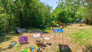 An outdoor play area with a ping pong table, a seesaw, and various toys. - Holiday home Batida Crikvenica by Villas Guide (Crikvenica)
