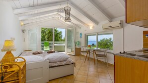 A bedroom with a bed, a chair, a table, and a view of the outdoors. - Holiday home Batida Crikvenica by Villas Guide (Crikvenica)