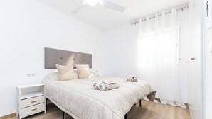 A bedroom with a bed, bedside tables, a ceiling fan, and a window with curtains. - Apartment at Origen Tepoztlán 8 (Torrent)