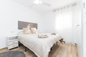 A bedroom with a bed, bedside tables, a ceiling fan, and a window with curtains. - Apartment at Origen Tepoztlán 8 (Torrent)