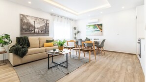 A modern living room with a sofa, coffee table, and dining area. - Apartment at Origen Tepoztlán 8 (Torrent)
