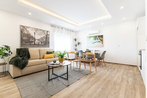 A modern living room with a sofa, coffee table, and dining area. - Apartment at Origen Tepoztlán 8 (Torrent)