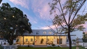 A modern house with a well-maintained lawn, a large tree, and a fountain. - Apartment at Origen Tepoztlán 8 (Torrent)