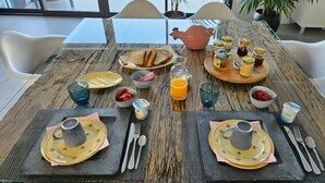 A breakfast table set with plates, cutlery, and various food items.