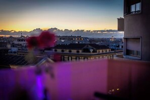 Eine Stadtansicht im Dämmerlicht mit Gebäuden und einer Kuppel in der Ferne.
