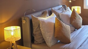 A hotel room with a bed, two wall-mounted lamps, and two framed artworks. - Luxury Apartment • 3 Suites • 2 Parking Lots • 5 min Downtown (Strasbourg)