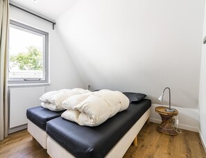A bedroom with a bed, a window, and a bedside lamp. - Home Near Vlissingen Beach (Vlissingen)
