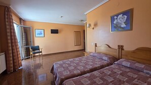 A hotel room with two beds, a chair, a window with curtains, a painting on the wall, and a door.