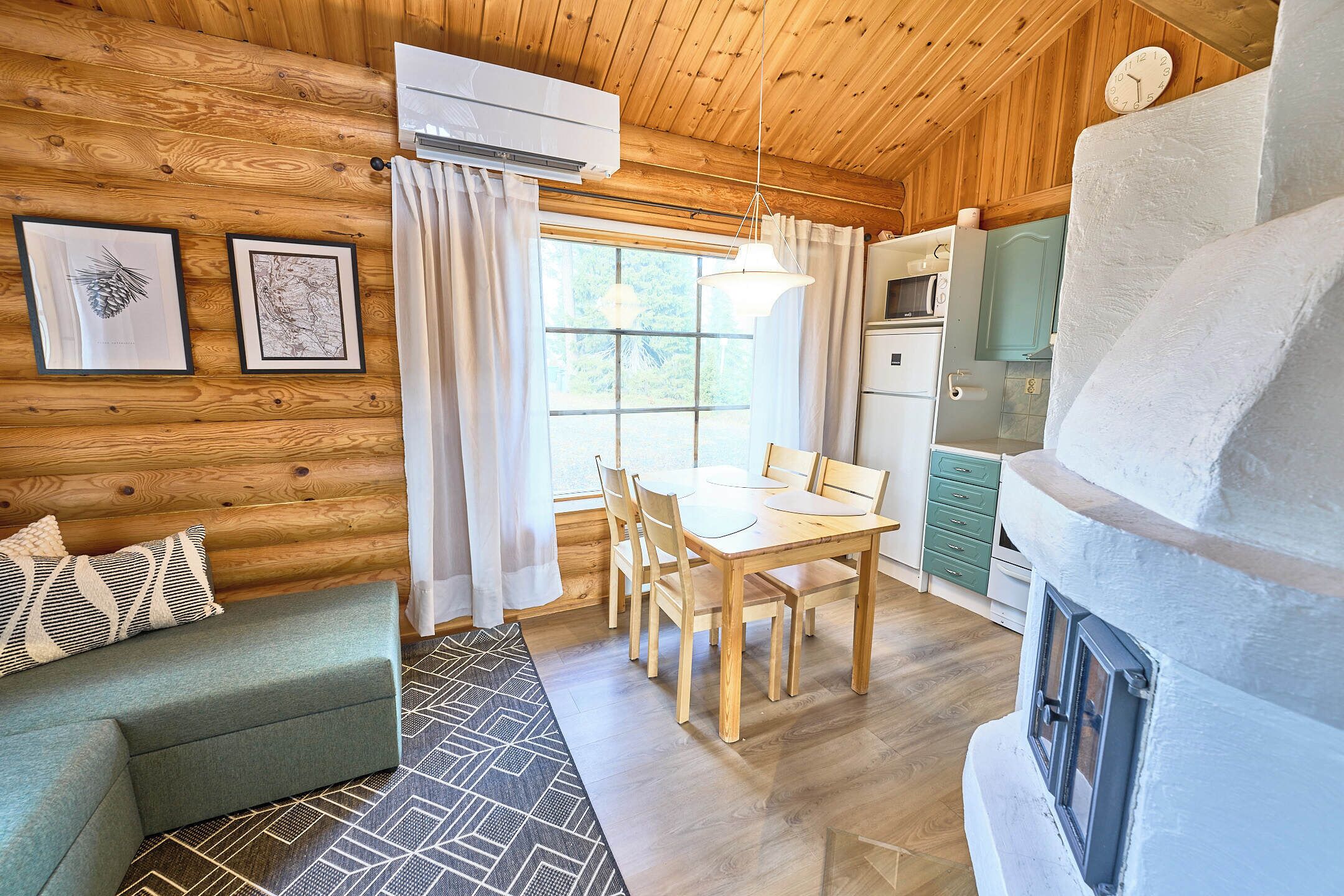 A log cabin interior with a dining area, kitchen, and a cozy seating area.