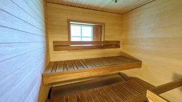 Una sauna con bancos de madera y una ventana.