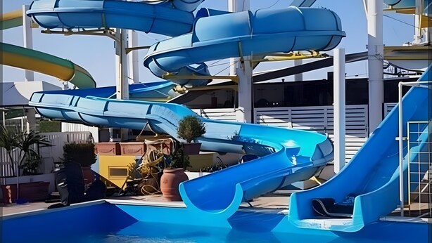 Um parque aquático com várias escorregas e uma piscina.