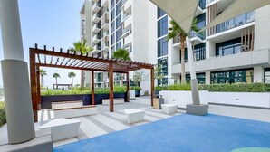 Ein moderner Außenbereich mit einer Holzpergola, Sitzgelegenheiten und einem Pool.