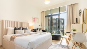 Ein modernes Hotelzimmer mit einem großen Bett, einem Schreibtisch und Blick auf die Stadt.