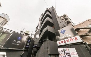Een hotel met een modern design, met balkons en een opvallend bord.