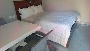 Un dormitorio con cama, escritorio y silla.