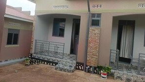 Una casa de dos pisos con un porche cubierto, una pequeña escalera y un ventanal.