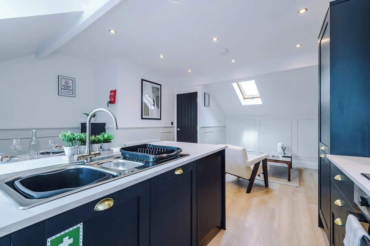 A modern kitchen with a central island, built-in appliances, and a dining area with a view.