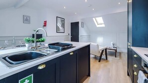 Een moderne keuken met een centraal eiland, ingebouwde apparatuur en een eethoek met uitzicht.