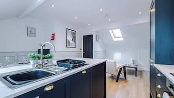 A modern kitchen with a central island, built-in appliances, and a dining area with a view.