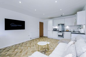 A modern kitchen with white cabinets, a built-in oven, and a coffee machine. - Spacious 2BR | Sleeps 6 | Parking | Walk to Etihad (Greater Manchester)