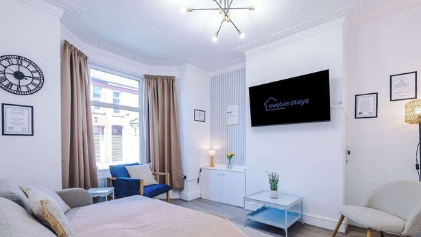 Ein modernes Hotelzimmer mit Bett, Fernseher, Schreibtisch und Stuhl.