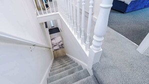 Eine Treppe mit weißen Spindeln, die zu einer Zwischenebene führt.