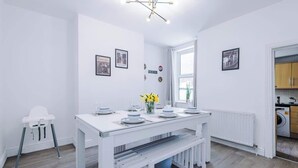 Eine moderne Küche mit weißen Schränken, einem eingebauten Geschirrspüler und einem Fenster für natürliches Licht.