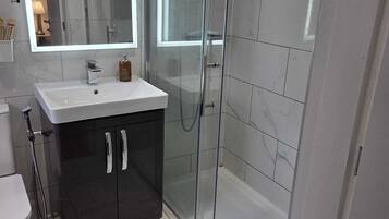 Chuveiro, secador de cabelo, toalhas de banho, shampoo