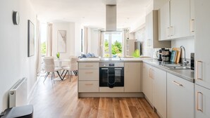 Una cocina moderna con horno integrado, cafetera y vistas al exterior.