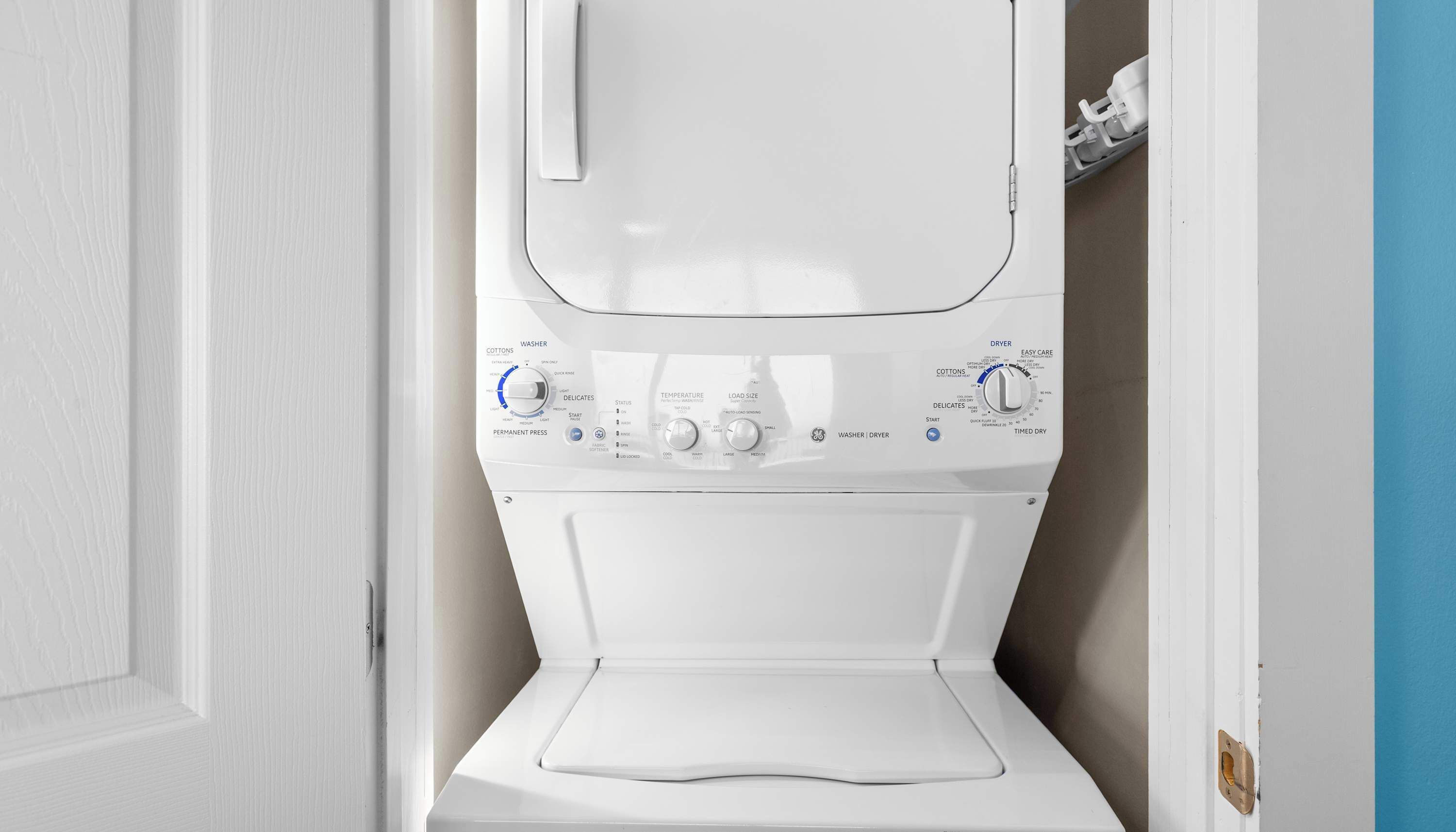 A front view of a white washing machine with control knobs and a door.
