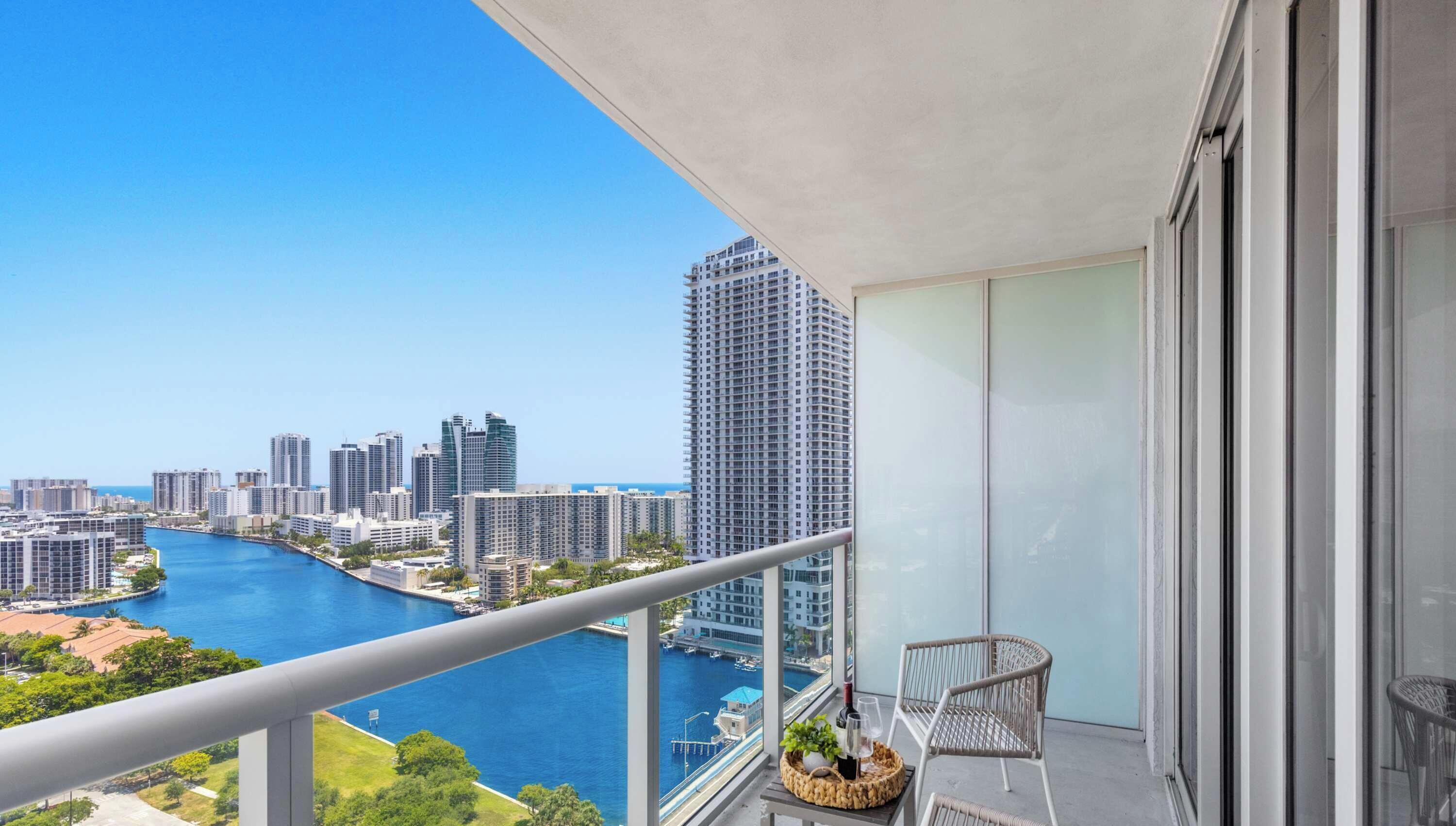 A balcony with a view of a city skyline and a river.