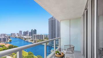 A balcony with a view of a city skyline and a river.