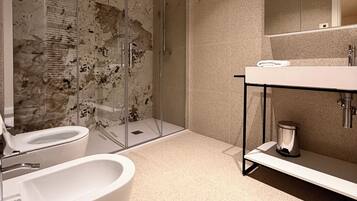 A modern bathroom with a glass-enclosed shower, a freestanding bathtub, and a vanity with a mirror.