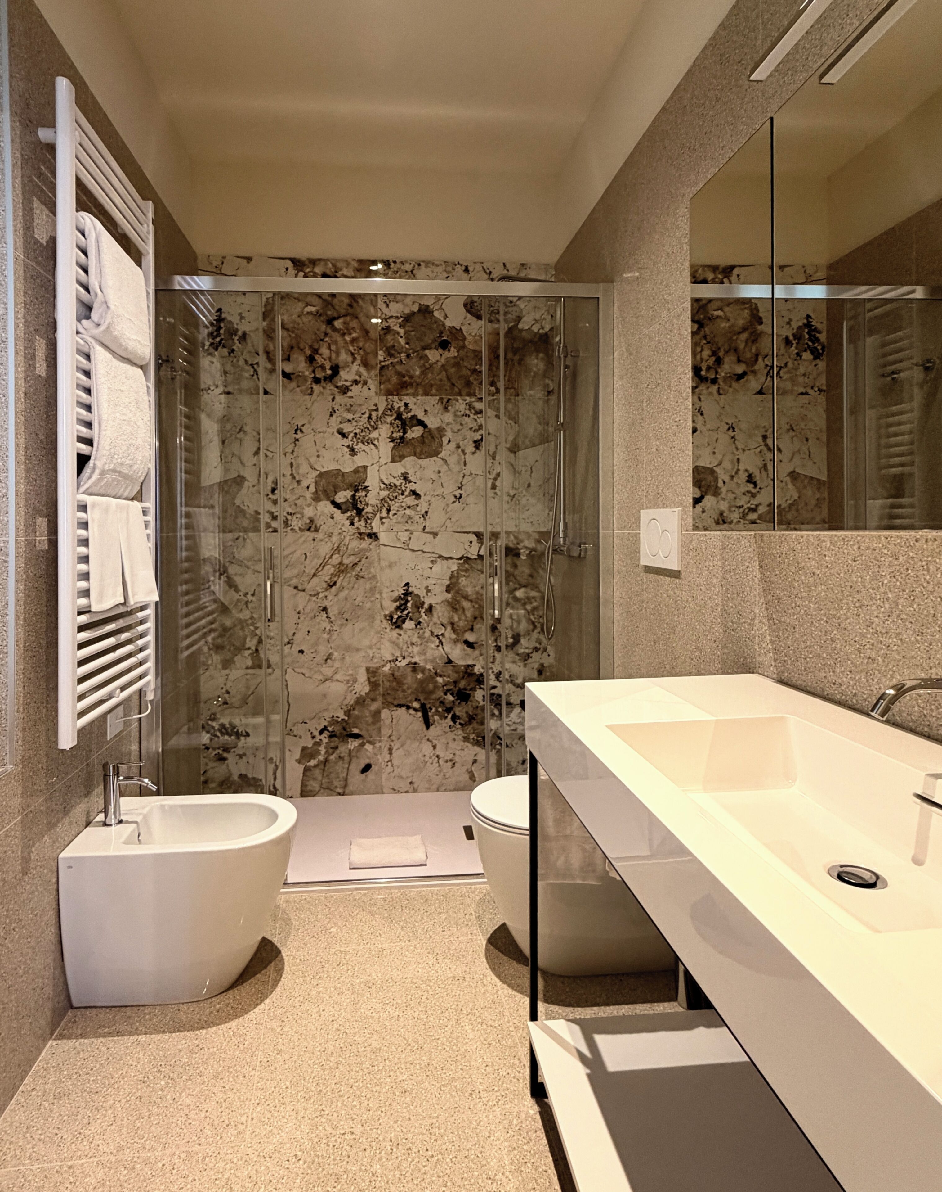 Un baño moderno con bañera, cabina de ducha y un espejo grande.