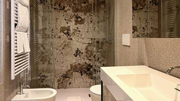 Un baño moderno con bañera, cabina de ducha y un espejo grande.