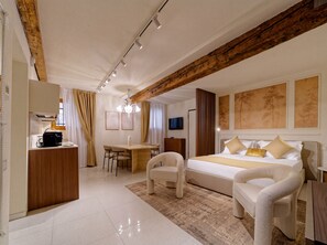 A hotel room with a bed, a desk, a chair, a television, and artwork on the walls.
