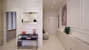 A hallway with a mirror, a console table with decorative items, a sofa, and a wall-mounted picture. - Be Mate Santa Croce (Venezia)