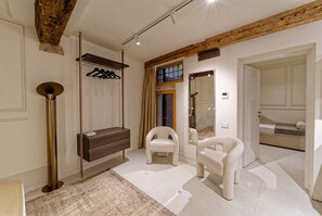 A modern bathroom with a wooden ceiling, a mirror, a towel rack, and a bench.