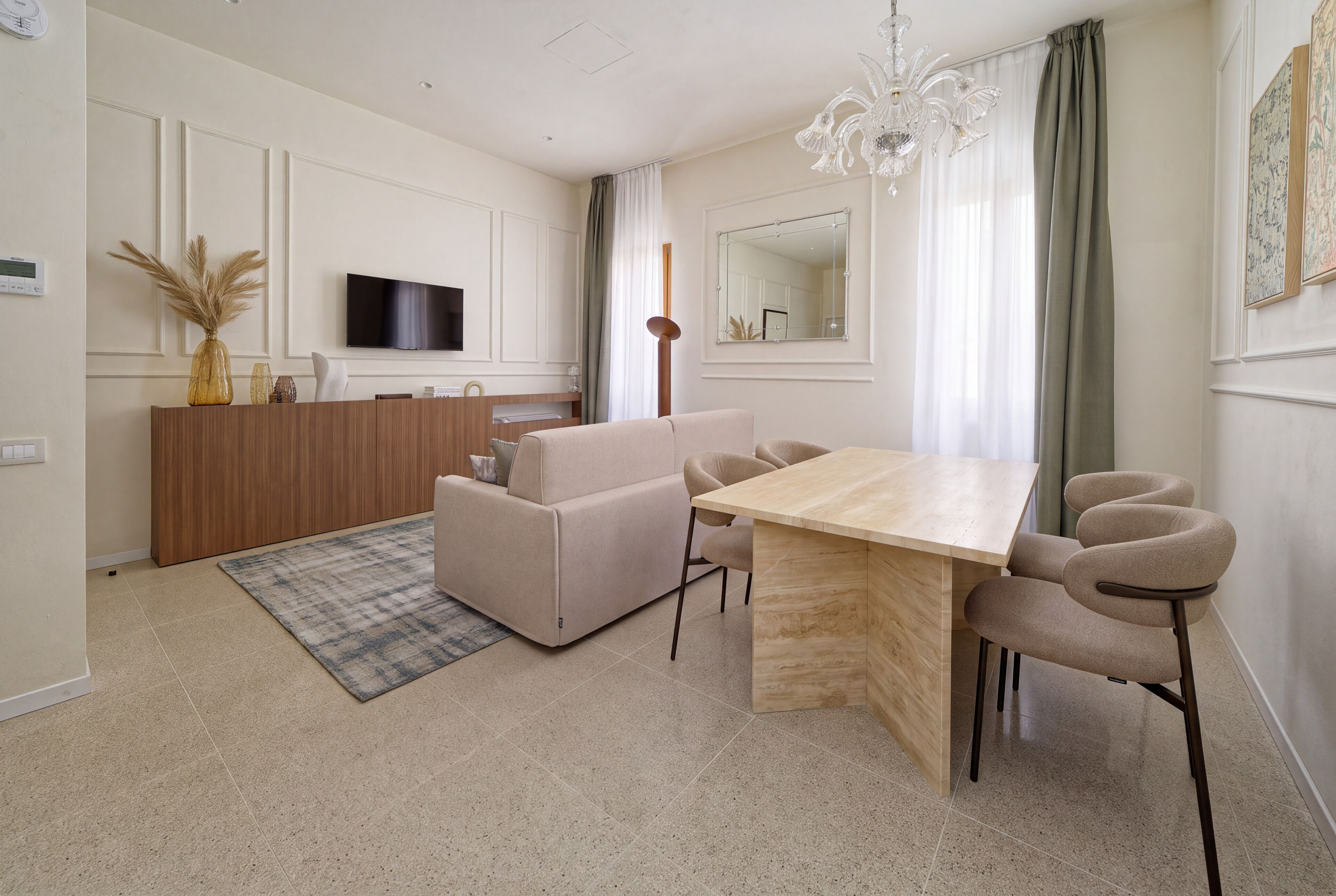 Una sala de estar moderna con un sofá, una mesa de comedor y sillas.