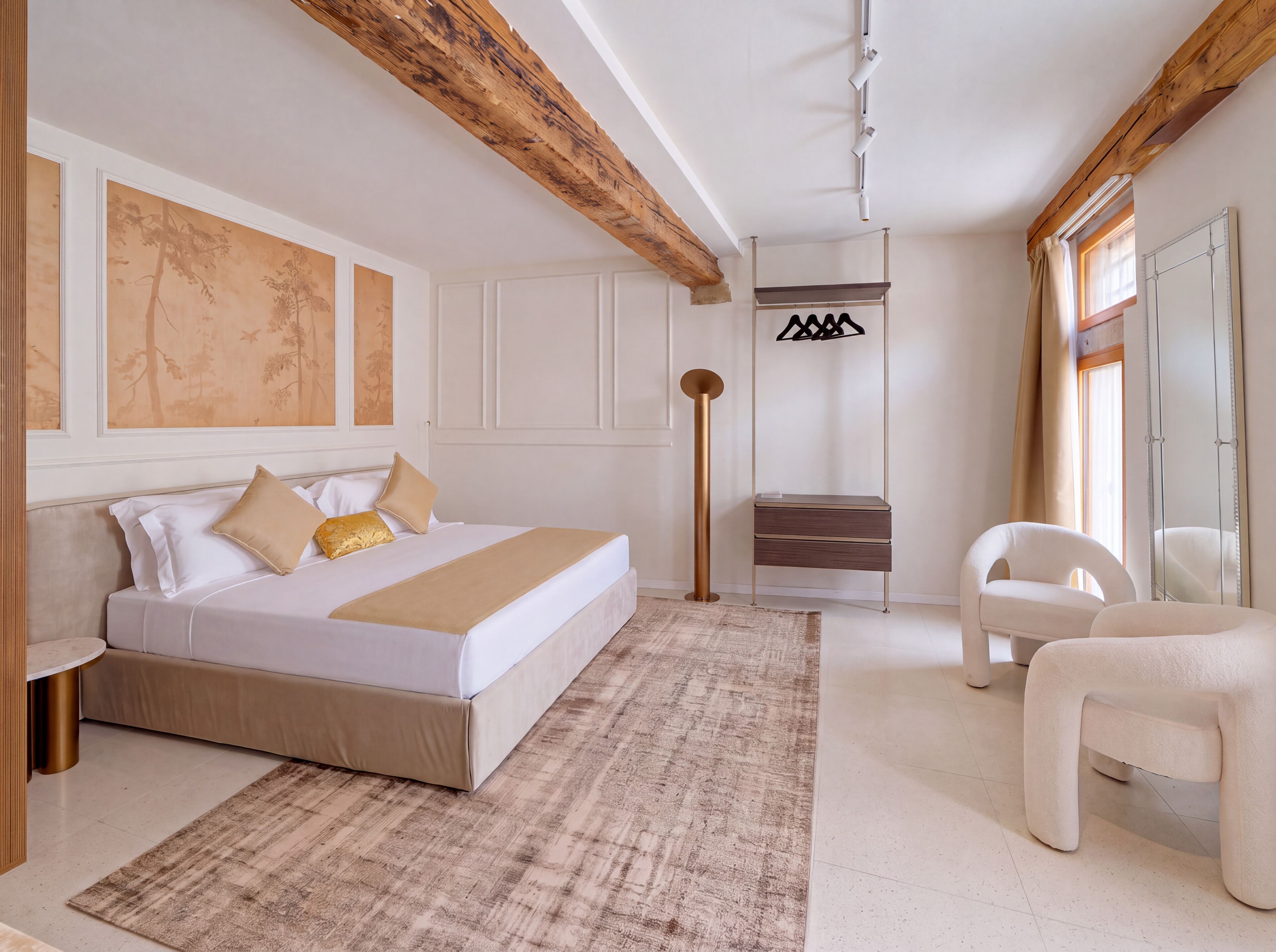 Une chambre à coucher avec un grand lit, une table de chevet, une chaise, une lampe sur pied et une armoire.