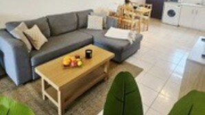 Un salon comprenant un canapé, une table basse et un coin repas avec des chaises.