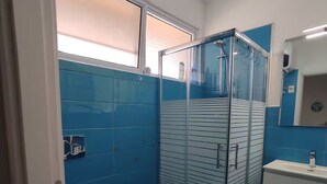 A bathroom with a glass shower enclosure, a bidet, and a toilet. - Otta's House (Platamona)