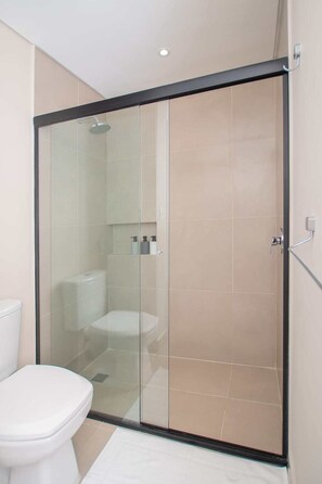 A modern bathroom with a glass-enclosed shower, a toilet, and a sink. - Corporate Stays Spirit Mariscal (Asunción)