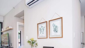 Eine moderne Küche mit einer Holzausziehtheke, einem Laptop und gerahmten Pflanzenbildern an der Wand.