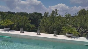 A clear swimming pool with lounge chairs and potted plants. - Villa Marica (Ostuni)