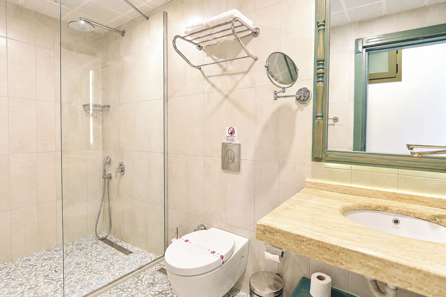 Une salle de bain équipée d’une douche, de toilettes, d’un lavabo et d’un miroir.