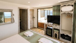 A bedroom with a bed, a television, a small table, and a walk-in closet. - Payam Agora Hotel Room Only, Shared Terrace & Kitchen (Kas)
