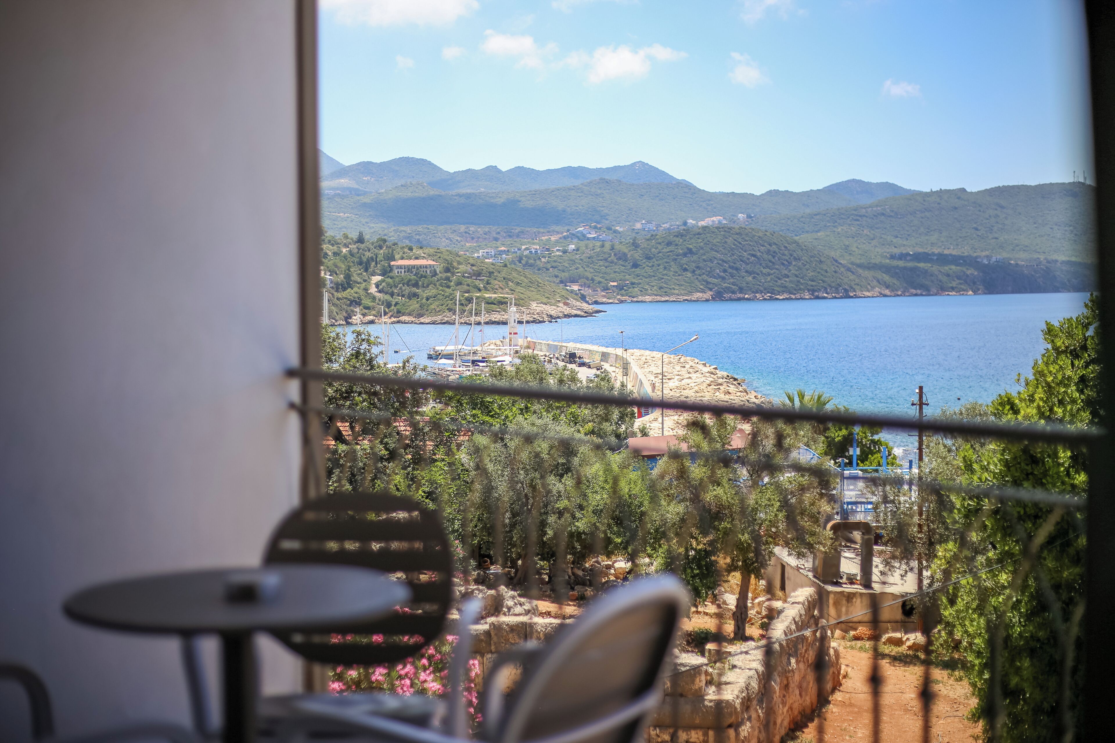 Varanda com vista para a área costeira, incluindo um corpo de água e montanhas ao longe.