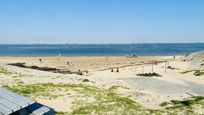 A beach with people, a sandy area, and a body of water. - Waterview Chalet Near Marina Beach (Sint-Annaland)