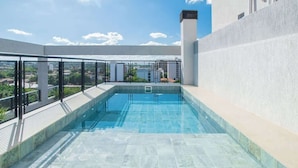 An indoor swimming pool with a clear view of the surrounding buildings and a staircase leading to an upper level. - Corporate Stays Spirit Villa Morra (Asunción)